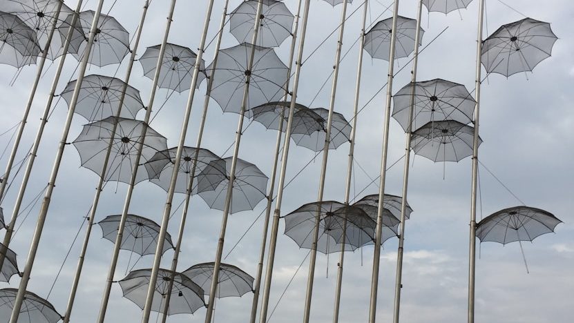 a bunch of umbrellas that are on a pole